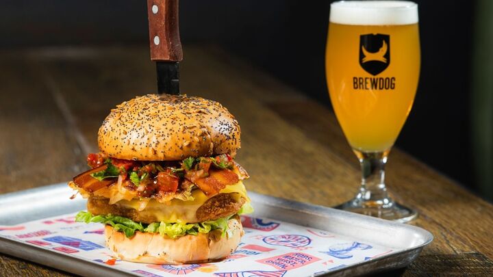Brewdog burger with a knife in it and a pint of beer