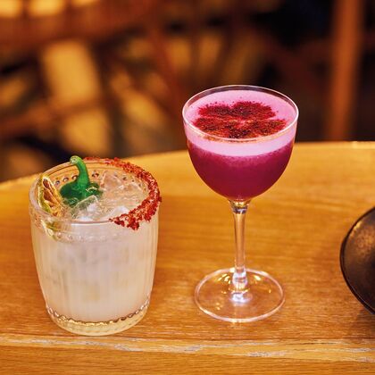 A margarita mocktail and a pink berry mocktail on a table
