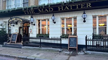 view of the ground floor door and windows of the mad hatter hotel from the street