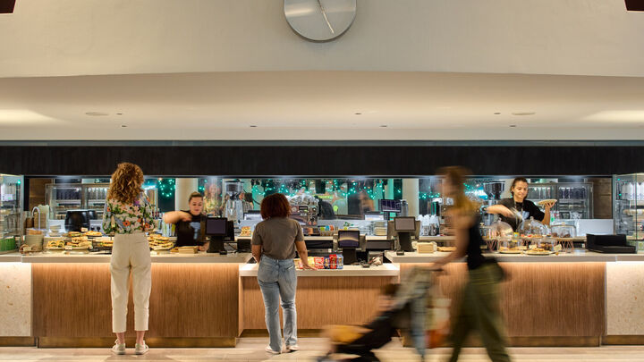 Two people standing at the bar counter waiting to be served