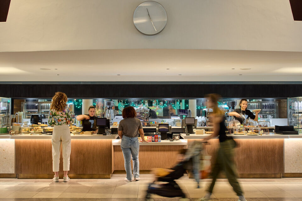 Two people standing at the bar counter waiting to be served