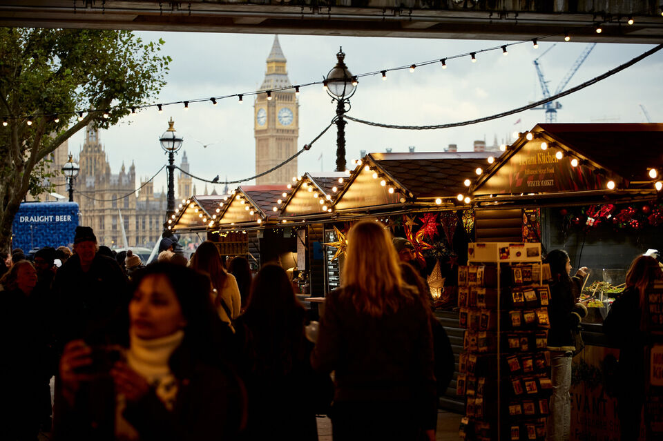 Crowds browse the market chalets with Big Ben in the back ground