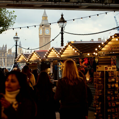 Crowds browse the market chalets with Big Ben in the back ground