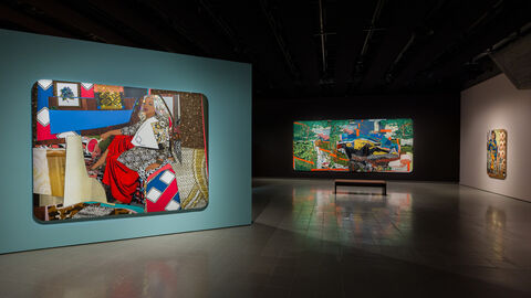 A view of art gallery with three very large canvases showing colourful portraits of women decorated with rhinestones