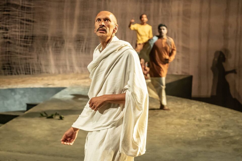 Actor Paul Bazely wearing a white robe playing Gandhi on stage